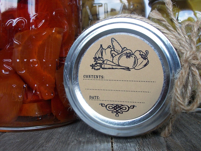 May include: A brown paper label with a black illustration of vegetables, including a tomato, pepper, onion, and carrots. The label is attached to a silver jar lid with a brown twine bow. The text on the label reads "CONTENTS:" and "DATE:".