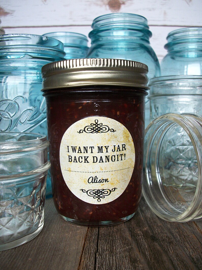 May include: A glass jar filled with a dark red substance, with a white label that reads "I WANT MY JAR BACK DANGIT!" and "Alison". The jar is surrounded by other glass jars.
