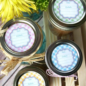 May include: Four glass jars with lids, each with a different coloured gingham patterned label. The labels have a blank space for writing the date and contents.