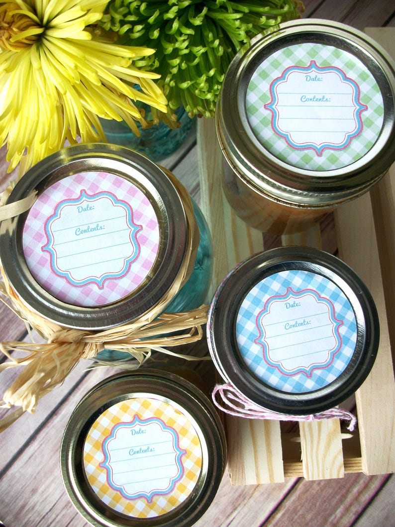 May include: Four glass jars with lids, each with a different coloured gingham patterned label. The labels have a blank space for writing the date and contents.