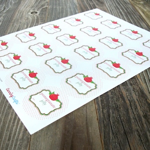 May include: Printable sheet of 20 white labels with red polka dots. Each label features a green and gold frame with a red pomegranate illustration and the text "pomegranate jelly".