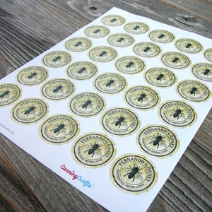 May include: A sheet of 24 round honey jar labels with a vintage design. The labels are beige with a black bee illustration and the text "Fernando's Honey Harvested with Love".
