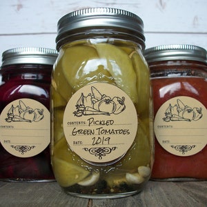 May include: Three glass jars with brown paper labels. The center jar contains pickled green tomatoes and has a label that reads "Contents: Pickled Green Tomatoes 2019".