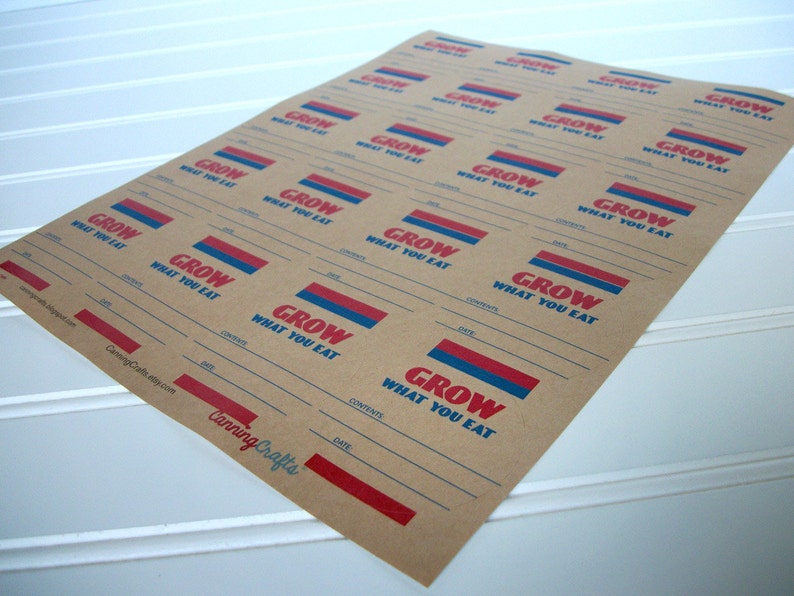 May include: A sheet of brown paper with multiple labels printed on it. Each label has the text "GROW WHAT YOU EAT" in red and blue lettering. The labels have lines for writing the date, contents, and other information.