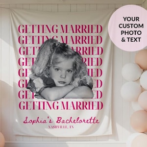 May include: A cream-colored fabric backdrop featuring the repeated dark pink text GETTING MARRIED, a black and white photograph of a young child with arms crossed, and the custom text Sophia's Bachelorette and NASHVILLE, TN in dark pink.