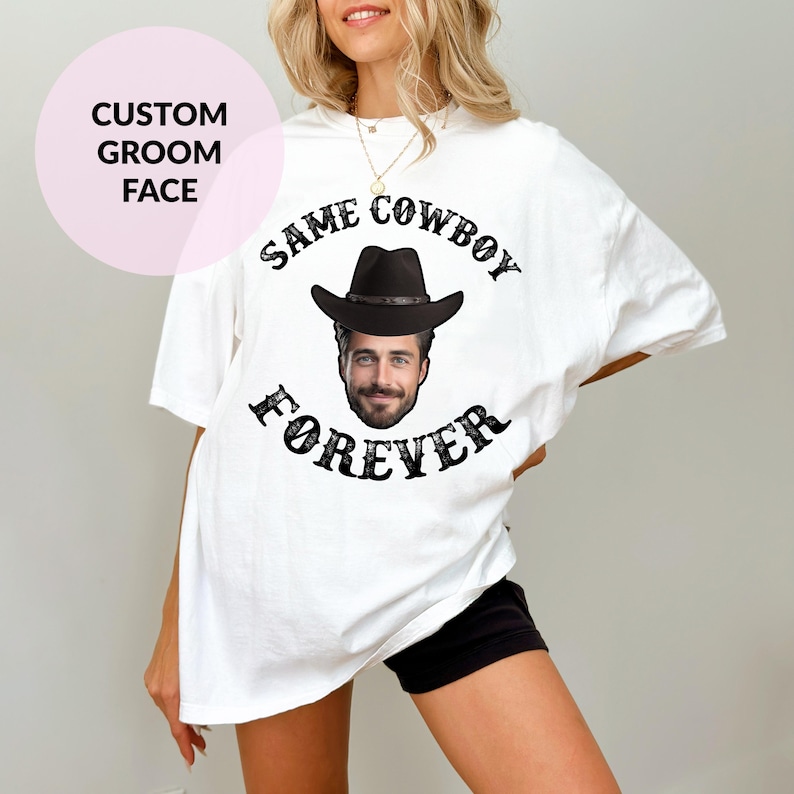 May include: White t-shirt with a black cowboy hat and face graphic. The text "SAME COWBOY FOREVER" is printed on the shirt.