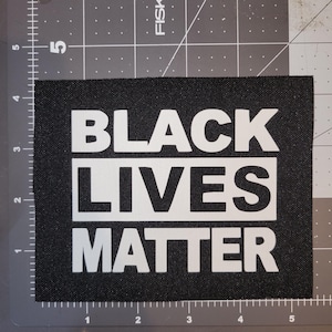 May include: Black Lives Matter patch with white text on a black background.