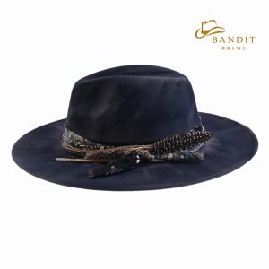 May include: A navy blue fedora hat with a wide brim, adorned with a patterned band and decorative feathers. The hat features the "Bandit Brims" logo in gold. This stylish hat is a fashion accessory.