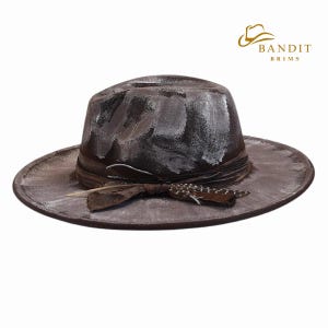 May include: A distressed brown fedora-style hat with white paint strokes. The hat features a brown ribbon band with a feather and decorative accent. The hat has a wide brim and the brand name "BANDIT BRIMS" is visible.