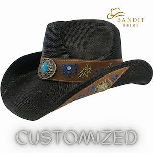 May include: Black cowboy hat with a brown leather band and turquoise stone embellishment. The band is decorated with floral embroidery in shades of blue, yellow, and brown. The hat is labelled "Bandit Brims" and "Customized".