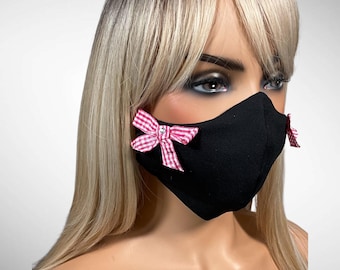 Mascarilla facial negra con lazos a cuadros rosas y blancos y detalles de diamantes de imitación