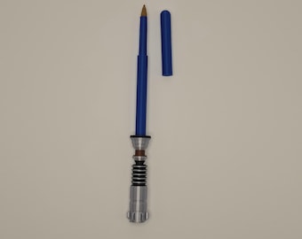 Pode incluir: Uma caneta azul com uma pega prateada e preta, projetada para se assemelhar a um sabre de luz. A caneta tem uma tampa removível e uma ponta dourada. A caneta é um item de novidade.