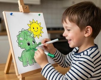 Pode incluir: Uma criança está a colorir um dinossauro verde e um sol amarelo num cavalete branco. A criança está a usar uma camisa às riscas e canetas verdes e brancas. O cavalete de madeira está numa mesa de madeira.