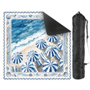 Op de afbeelding: Een vierkante strandmat met een aquarelprint van blauw-witte gestreepte parasols op een zandstrand met oceaangolven, omrand door een schelpenpatroon. De mat heeft een zwarte onderkant en wordt geleverd met een zwarte draagtas.