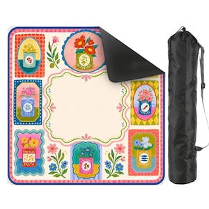 May include: A square picnic blanket featuring a cream-colored center and a border decorated with colorful illustrations of canned goods labeled Cherry Tomatoes, Olive Oil, Jasmine Tea, Chili Peppers, Farfalle Pasta, Island Coffee, and Salted Sardines.