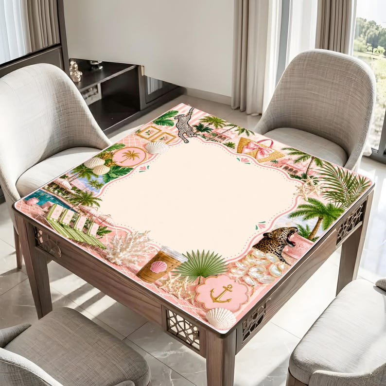 May include: A square wooden table with a decorative pink and cream-colored top featuring a tropical beach scene with palm trees, seashells, and a leopard. The table is surrounded by three chairs.