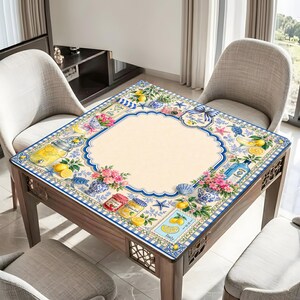 Puede incluir: Una mesa cuadrada de madera con una tapa decorativa con un dise&ntilde;o de lim&oacute;n y flores. La superficie de la mesa tiene un centro color crema con un borde azul. El dise&ntilde;o incluye limones, flores y tarros de conservas.