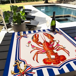 May include: A decorative lobster-themed game board with a red, white, and blue nautical design. The board features a large illustration of a lobster, surrounded by game pieces and anchor motifs. A bottle of champagne and a glass are on the table.