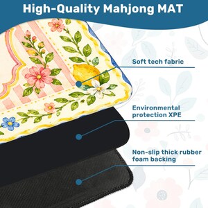 May include: A high-quality Mahjong mat with a floral and lemon design. The top layer features soft tech fabric, followed by environmental protection XPE, and a non-slip thick rubber foam backing. The mat has a cream-colored background with pink and blue flowers.