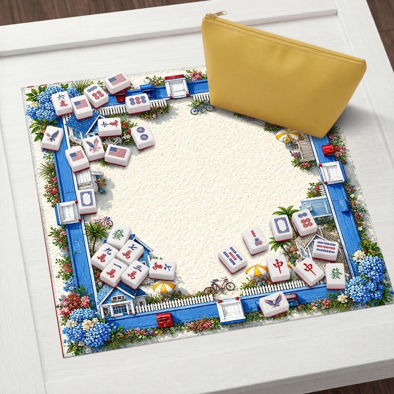May include: A yellow zippered pouch rests on a white surface next to a decorative border. The border features blue houses, flowers, and Mahjong tiles with various symbols and American flags. The background is a sandy texture.