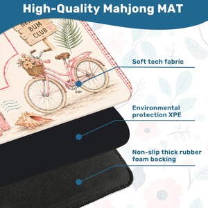 May include: A Mahjong mat featuring a pink bicycle with a flower basket, a seashell, and a sign reading Beach Bum Club. The mat is composed of three layers: a soft tech fabric top, an environmental protection XPE middle, and a non-slip rubber foam backing.