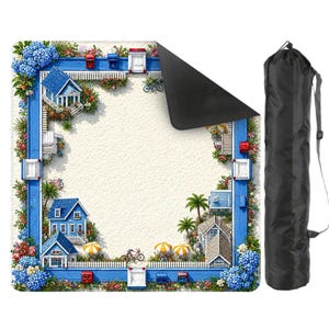 May include: A square picnic blanket with a beach scene border featuring blue houses, white picket fences, and colorful flowers. The blanket has a sandy background and a black underside. A black carrying bag is included.