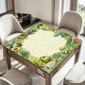 Puede incluir: Una mesa cuadrada de madera con una encimera decorativa con borde verde que presenta un dise&ntilde;o de acuarela de frutas, verduras y botellas. La mesa est&aacute; rodeada de sillas, creando un ambiente de comedor o sala de estar.