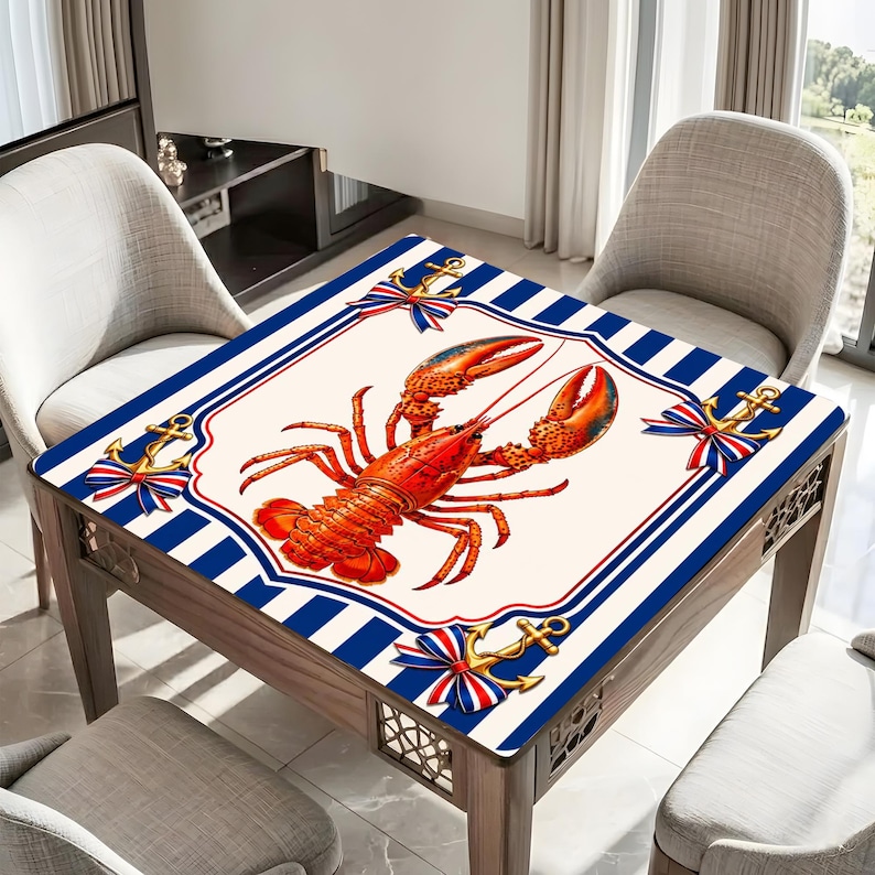 May include: Square wooden table with a nautical design. The tabletop features a large red lobster illustration on an off-white background, framed by a blue and white striped border. Gold anchors with red and blue ribbons decorate the corners.