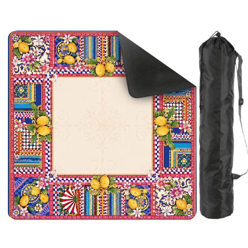 Pode incluir: Uma manta de piquenique colorida com uma borda decorativa com lim&otilde;es, flores e padr&otilde;es geom&eacute;tricos. A manta tem um centro creme e uma parte inferior preta. Uma bolsa de transporte preta est&aacute; inclu&iacute;da.