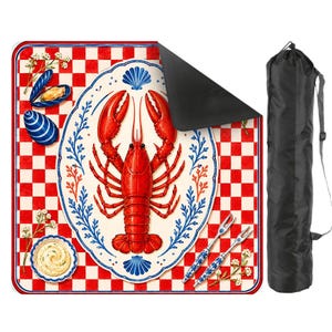 Op de afbeelding: Een picknickkleed met een rode kreeftillustratie op een wit bord met blauwe accenten, tegen een rood-wit geblokte achtergrond. Inclusief een zwarte draagtas en twee decoratieve vorken. Het kleed is ontworpen voor gebruik buitenshuis.