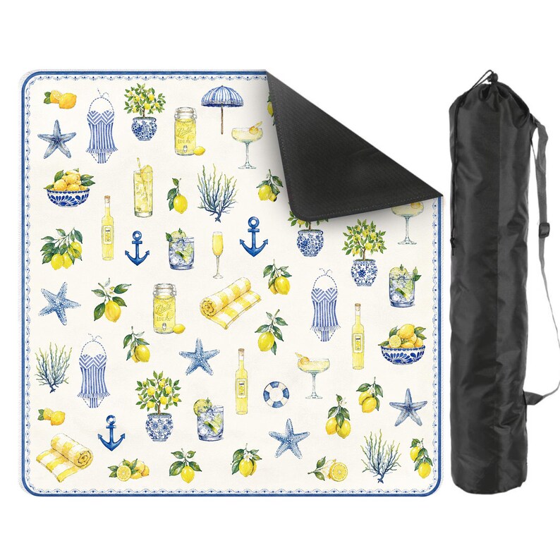 Puede incluir: Una manta de picnic blanca y azul con un dise&ntilde;o de lim&oacute;n y n&aacute;utico. La manta presenta limones, estrellas de mar, anclas e ilustraciones de c&oacute;cteles. Se incluye una bolsa de transporte negra.