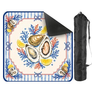 May include: A square mat with a nautical design featuring oysters, lemon slices, and blue and red accents. The mat has a white center with a decorative border and blue and white striped edges. A black carrying bag is included.