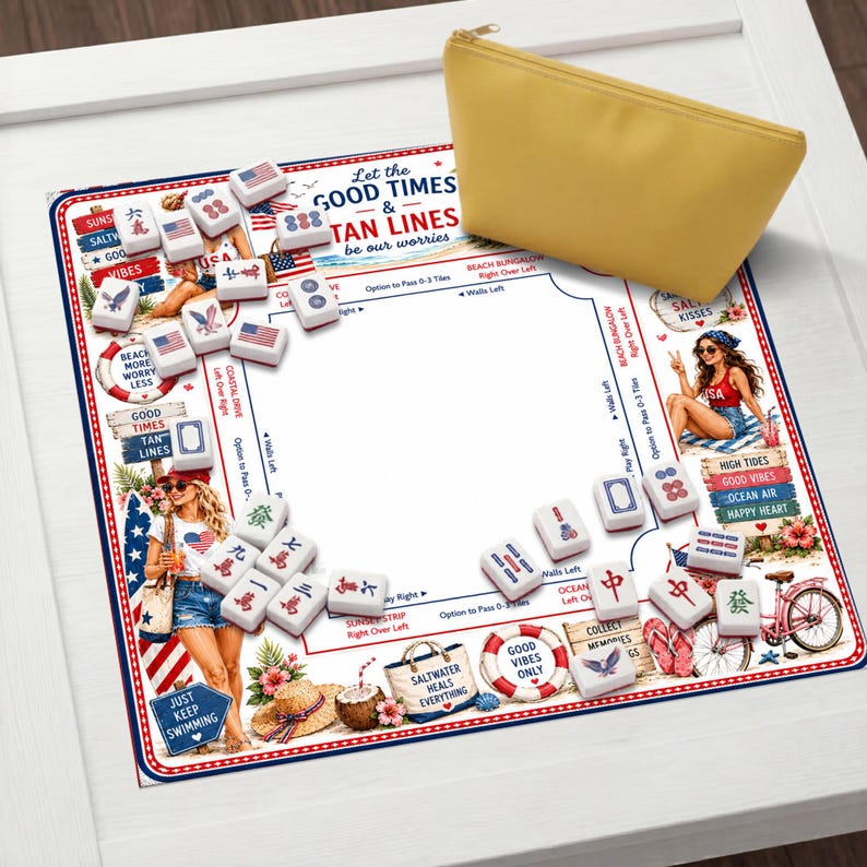 May include: A square Mahjong mat featuring a beach-themed design with illustrations of people, surfboards, and text including Let the GOOD TIMES & TAN LINES be our worries, alongside scattered white Mahjong tiles and a solid yellow zippered pouch.
