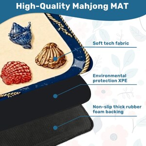 May include: A high-quality Mahjong mat with a nautical theme. The mat features a cream-colored surface with blue trim and rope detailing. Three seashell illustrations in red, gold, and blue are displayed. The mat has a soft tech fabric, environmental protection XPE, and a non-slip rubber foam backing.