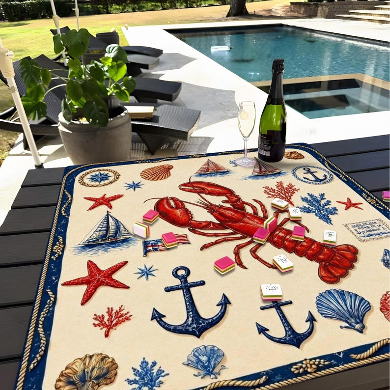 May include: A nautical-themed placemat featuring a large red lobster, anchors, seashells, sailboats, and starfish. The placemat has a cream-colored background with a blue border and is decorated with various nautical elements.