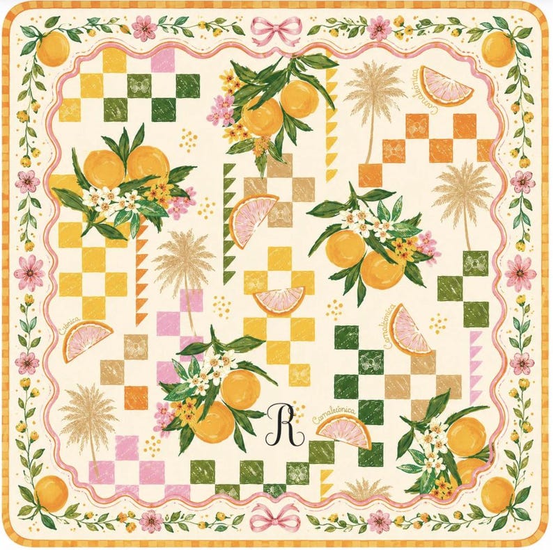 May include: Square decorative scarf with a cream background featuring orange and green checkered patterns, orange fruit illustrations, palm trees, and floral accents. The border is adorned with flowers and oranges. A pink ribbon and the letter "R" are also visible.