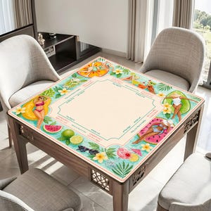 Op de afbeelding: Een vierkante houten tafel met een decoratief blad met een strandthema. Het ontwerp bevat illustraties van vrouwen in badkleding, tropisch fruit en cocktails. De tafel is omringd door stoelen.