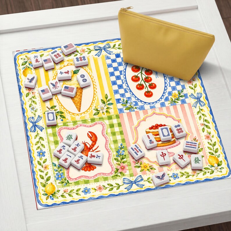 May include: A colorful Mahjong game set with tiles featuring various symbols and designs, including American flags and Chinese characters. A yellow zippered pouch sits on the corner of the game mat. The mat has a floral and patterned design.