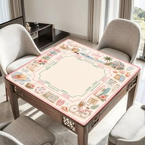 May include: A square mahjong mat featuring a cream-coloured centre and a border decorated with beach-themed illustrations including a bicycle, surfboards, palm trees, and flip-flops. The mat includes text such as Good Vibes, Beach Bum Club, and Aloha.