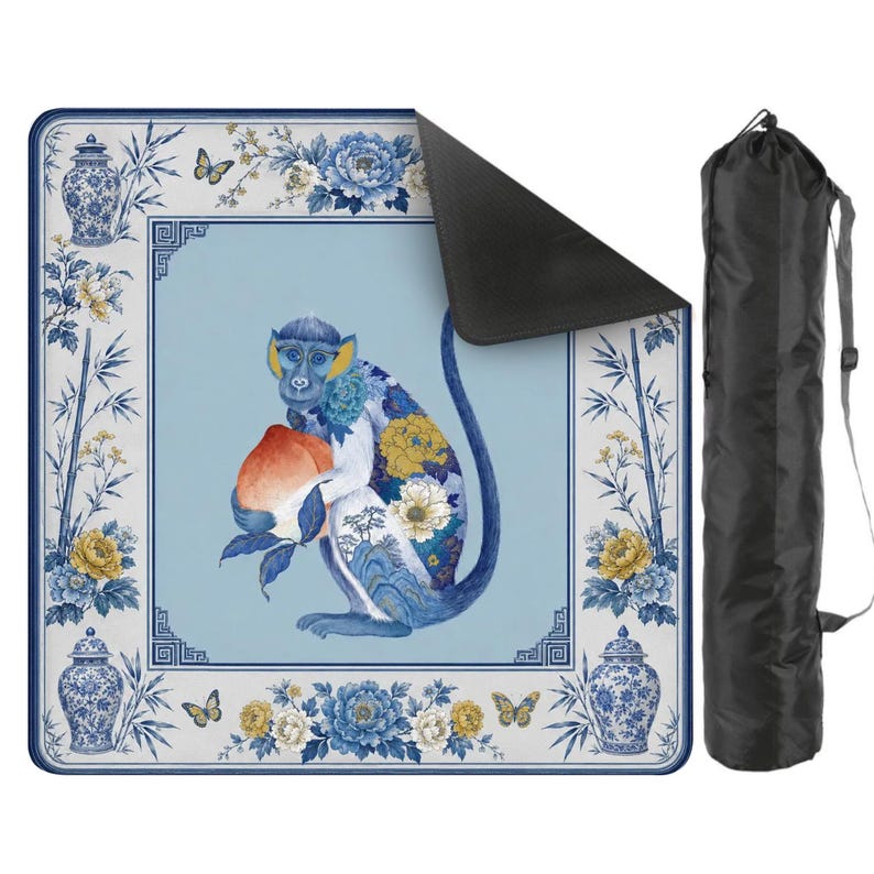 K&ouml;nnte beinhalten: Yoga-Matte mit einem blauen Affen, der einen Pfirsich h&auml;lt, mit floralen und Schmetterlingsmotiven. Die Matte hat einen hellblauen Hintergrund und eine schwarze Tragetasche. Das Design umfasst blaue und gelbe Blumen und Bambus.