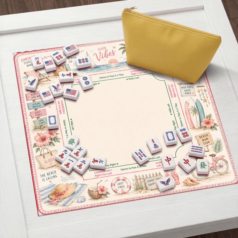 May include: A mahjong game set featuring a rectangular play mat with a beach-themed illustration, including surfboards, a bicycle, and tropical flowers. The mat includes game instructions and text like Good Vibes. Includes white tiles and a yellow pouch.