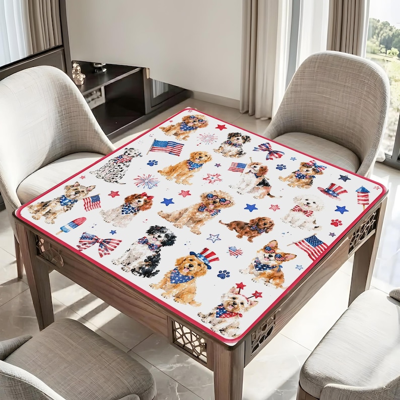 May include: A square tablecloth featuring a repeating pattern of various dog breeds wearing patriotic accessories like red, white, and blue bandanas and hats, interspersed with American flags, fireworks, and stars on a white background.