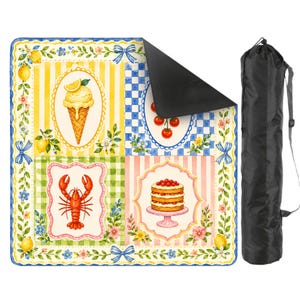 May include: A colorful picnic blanket with a whimsical design featuring ice cream, cherries, a lobster, and a cake. The blanket has a black underside and comes with a black carrying bag. The design includes yellow, blue, green, and pink patterns.