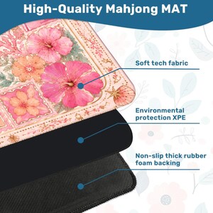 May include: A Mahjong mat featuring a floral pattern with pink and orange hibiscus flowers, shells, and coral. The mat consists of three layers: a soft tech fabric top, an environmental protection XPE middle layer, and a non-slip thick rubber foam backing.