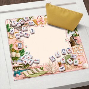 May include: A yellow zippered pouch rests on a decorative mat featuring a tropical scene with a pool, lounge chairs, and a leopard. The mat is surrounded by mahjong tiles with various symbols and American flag designs.
