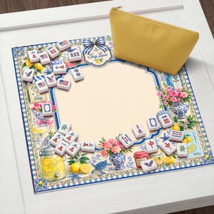 Puede incluir: Un juego de Mahjong decorativo con un dise&ntilde;o floral y n&aacute;utico. El juego incluye fichas, una bolsa amarilla y un tapete estampado con el texto "Tiny Louis". El tapete presenta limones, flores y el texto "Italy".