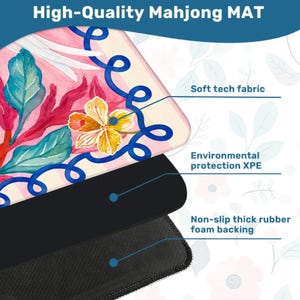 May include: A high-quality Mahjong mat with a floral design featuring pink, blue, and yellow colors. The mat has a soft tech fabric surface, environmental protection XPE, and a non-slip thick rubber foam backing. The text "High-Quality Mahjong MAT" is at the top.