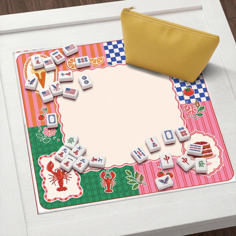 May include: A yellow zippered pouch rests on a colorful mat with a pink and green border. The mat features illustrations of food, flags, and Mahjong tiles. The tiles are white with black symbols. The mat is on a white surface.