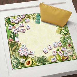 Puede incluir: Un juego de mahjong decorativo con fichas con dise&ntilde;os de banderas americanas y caracteres chinos. El juego incluye una bolsa con cremallera amarilla y se exhibe sobre un tapete verde y crema con ilustraciones bot&aacute;nicas.