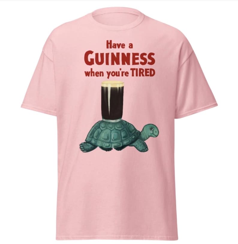 May include: Pink t-shirt with the text "Have a GUINNESS when you're TIRED" in red. A cartoon turtle is carrying a glass of Guinness.